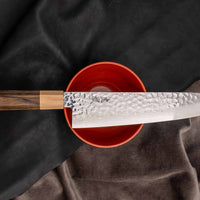 Kotetsu Gyuto VG-10 Damascus 210 mm veliki svestrani je nož s vidljivim otiscima čekića i klasičnom japanskom (wa-style) drškom od pakka drva. Oduševit će svakega koji cijene i estetski oblikovane kuhinjske posuđe.