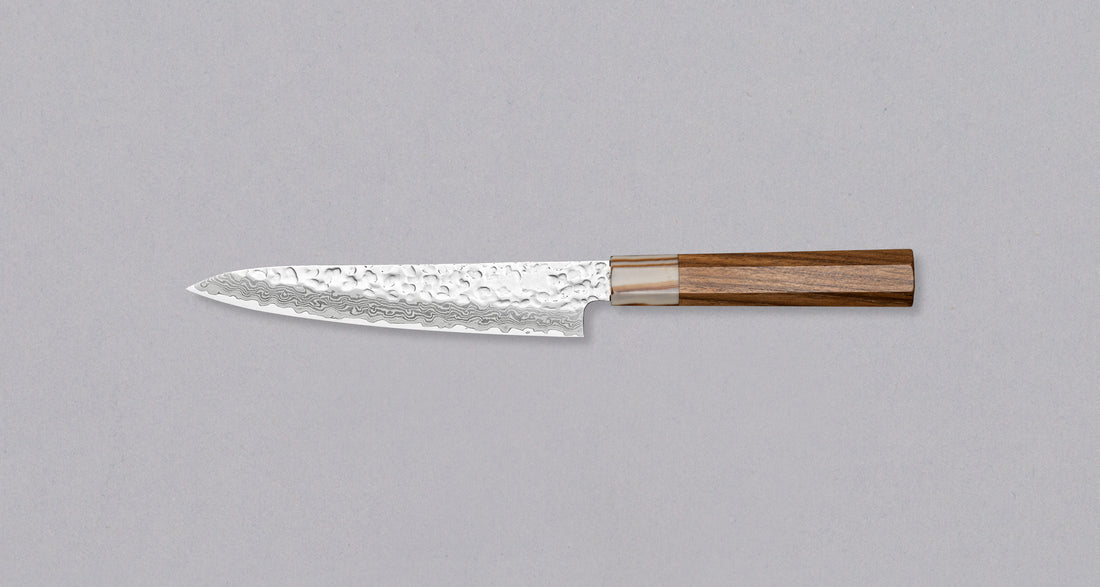 Kotetsu VG-10 Damascus Petty 150 mm je mali nož s vidljivim otiscima čekića i klasičnom japanskom (wa-style) drškom od tikovine. Nož je iznimno tanak (1,9 mm) tako da će s lakoćom kliziti kroz sastojke, a odabir VG-10 nehrđajućeg čelika osigurava otpornost na hrđu, izdržljivost i otpornost na habanje.