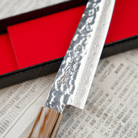 Kotetsu VG-10 Damascus Petty 150 mm je mali nož s vidljivim otiscima čekića i klasičnom japanskom (wa-style) drškom od tikovine. Nož je iznimno tanak (1,9 mm) tako da će s lakoćom kliziti kroz sastojke, a odabir VG-10 nehrđajućeg čelika osigurava otpornost na hrđu, izdržljivost i otpornost na habanje.