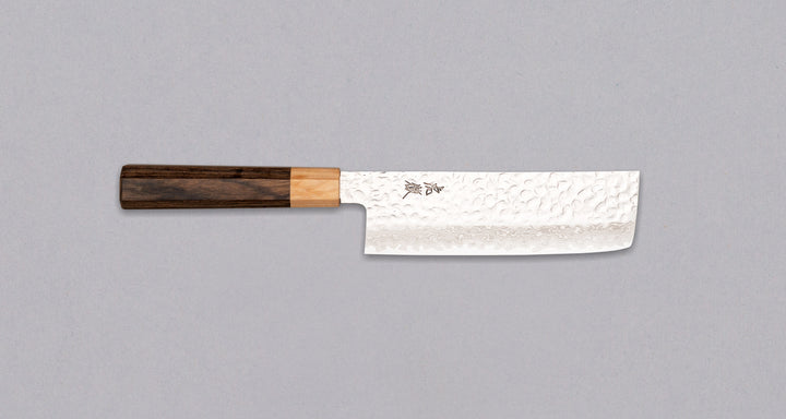 Kotetsu VG-10 Damascus Nakiri 160 mm je nož za povrće s vidljivim otiscima čekića i klasičnom japanskom (wa-style) drškom od pakka drva. Nož je iznimno tanak (1,9 mm) tako da će s lakoćom kliziti kroz sastojke, a odabir VG-10 nehrđajućeg čelika osigurava otpornost na hrđu, izdržljivost i otpornost na habanje.