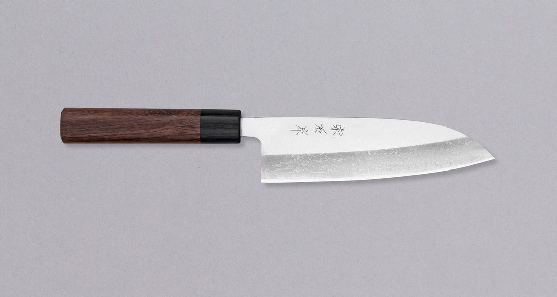 Muneishi Santoku Damascus 165 mm svestrani je japanski kuhinjski nož, namijenjen pripremi mesa, ribe i povrća. Damaščanski uzorak izrazit je na donjem dijelu oštrice, gdje se odjednom završi te prelazi u migaki, poliran do visokog sjaja. Japanska (Wa) drška od palisandera, udobna je za ljevake i za dešnjake.
