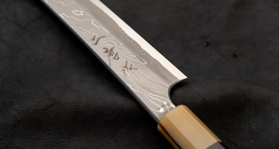 One of the most impressive collector's pieces we have on offer. This spectacular sakimaru yanagiba by the famous Nigara Hamono smithy is a fusion of excellent performance and outstanding aesthetics rarely matched in the world of knives. Core from Aogami #2 steel, twisted damascus lamination, fitted with ebony handle.