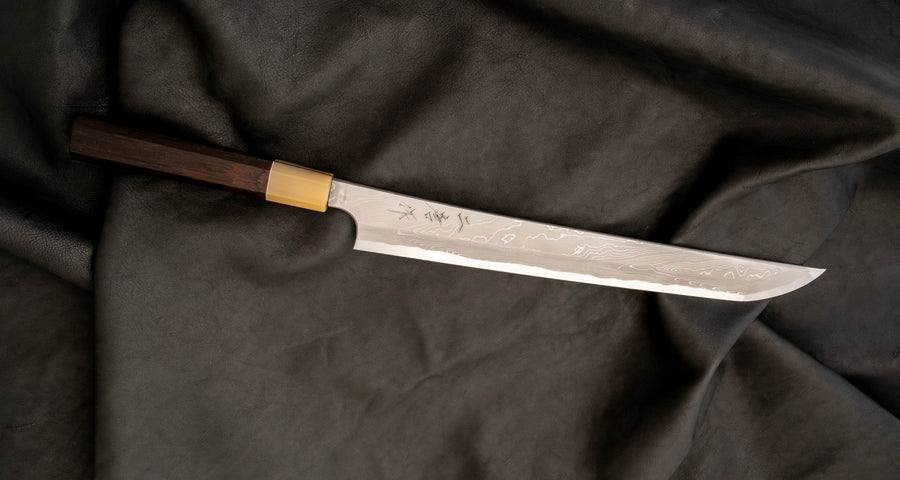 One of the most impressive collector's pieces we have on offer. This spectacular sakimaru yanagiba by the famous Nigara Hamono smithy is a fusion of excellent performance and outstanding aesthetics rarely matched in the world of knives. Core from Aogami #2 steel, twisted damascus lamination, fitted with ebony handle.