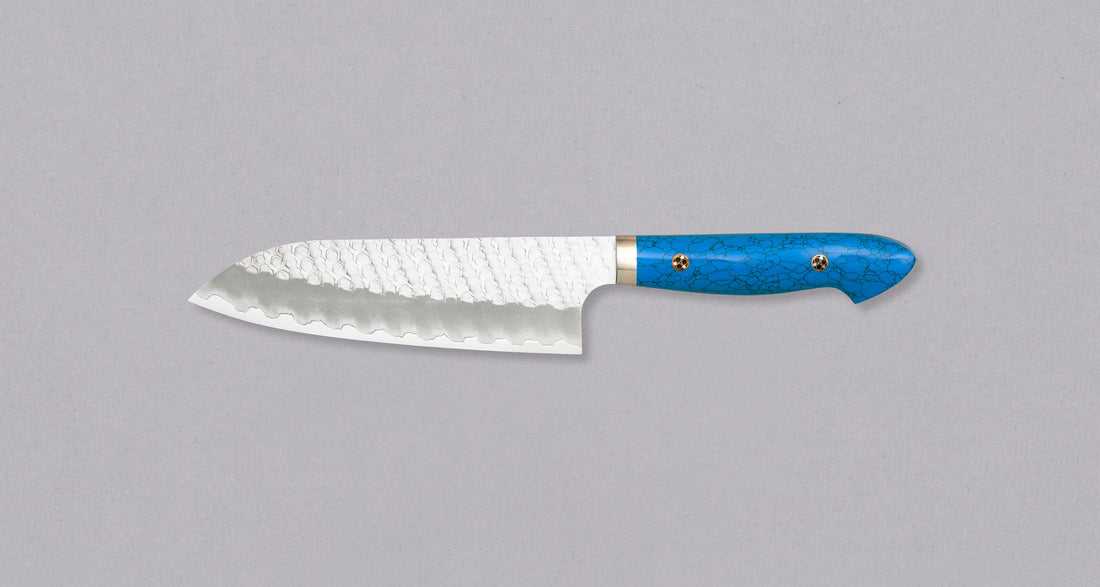 Nigara Santoku SG2 Migaki Tsuchime Turquoise 180 mm višenamjenski je japanski kuhinjski nož, pogodan za pripremu mesa, ribe i povrća. Jezgra od SG2 praškastog čelika i hamaguri presjek profila osiguravaju dugotrajnu oštrinu i minimalno održavanje. 