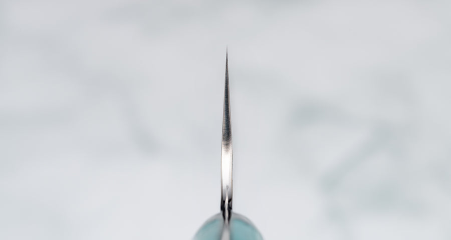 Choil. Nigara Santoku SG2 Migaki Tsuchime Turquoise 180 mm višenamjenski je japanski kuhinjski nož, pogodan za pripremu mesa, ribe i povrća. Jezgra od SG2 praškastog čelika osigurava dugotrajnu oštrinu i minimalno održavanje.