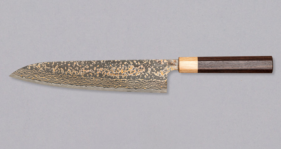 Noževi iz serije Gold kovača Takeshija Sajija dobivaju svoj značajan izgled zbog posebnog postupka laminacije u kojem je vanjskim slojevima dodan mesing te se time postiže zlatno obojen damaščanski uzorak. Čelik VG-10 ima nehrđajuća svojstva i visok udio ugljika. Tvrdoća iznad 60 HRC je jamstvo za iznimno finu oštrinu.