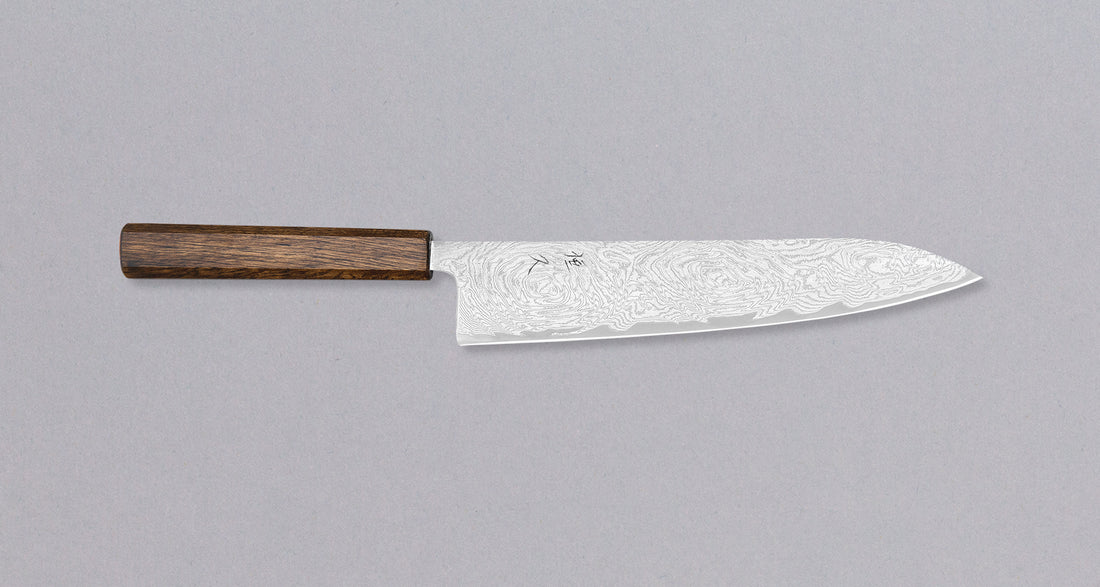 Tsunehisa Gyuto AUS-10 Nami 240 mm višenamjenski je japanski kuhinjski nož, prikladan za pripremu mesa, ribe i povrća. Izvrstan je odabir za sve one koji traže nož s malo dužom oštricom koji će bez poteškoća razrezati veće komade mesa ali iskazat će se i kao slicer nož. AUS-10 je nehrđajući čelik s finom oštrinom.