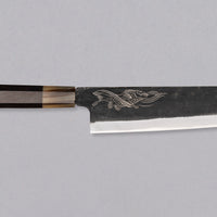 Yoshida Bunka SUJ-2 Kuro-uchi 190 mm je ručno izrađen kuhinjski nož srednje veličine od izdržljivog SUJ-2 čelika s rustikalnim kuro-uchi završetkom, idealan za razne zadatke i s jedinstvenom gravurom koi šarana.