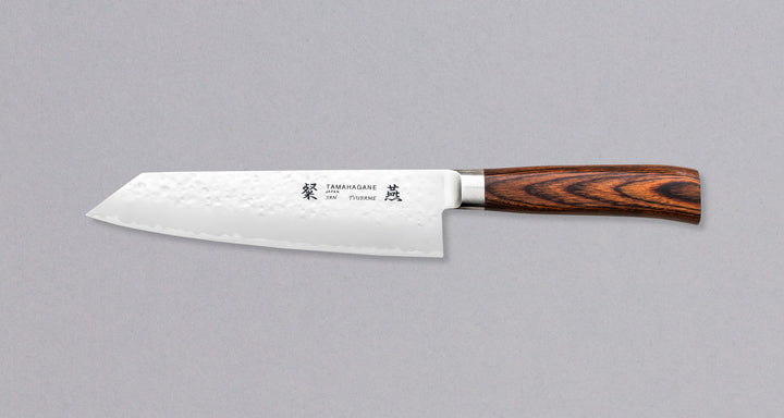 Tamahagane "TSUBAME" Kengata 190 mm_1Tamahagane San Kengata 190 mm ili Bunka je svestran kuhinjski nož koji će blistati prilikom sjeckanja i rezanja na kuhinjskoj dasci. Veličina oštrice je 190 mm.  Noževe Tamahagane izrađuju u Nigati u Japanu, u regiji poznatoj po proizvodima od čelika. Napravljeni su na tradicionalan način uz upotrebu moderne tehnologije. 